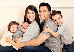 a man and woman holding two small children