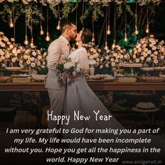 a newly married couple kissing in front of a table with flowers and candles on it