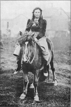 an old black and white photo of a woman on a horse