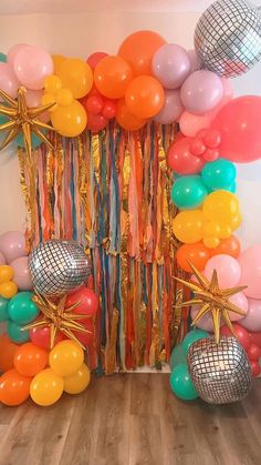 balloons, streamers and disco balls are arranged on the floor