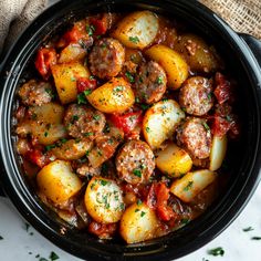 a bowl filled with meat and potatoes on top of a table