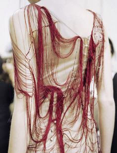 the back of a woman's dress covered in red thread