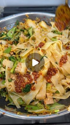 a pan filled with pasta and broccoli on top of a stove