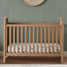 a wooden crib in a room with green walls