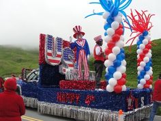 a parade float decorated with balloons and streamers