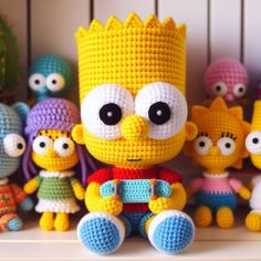 crocheted simpsons characters sitting next to each other in front of a white shelf