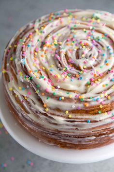 a cake with frosting and sprinkles sitting on a white platter