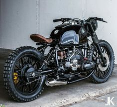 a black motorcycle parked in front of a building with no one on it's bike