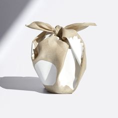 a white and beige bag with a bow on it