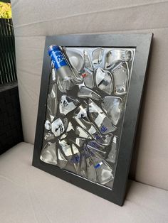 an ice tray with silver spoons in it and a blue bottle sitting next to it