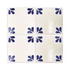 four blue and white tiles with flowers on them