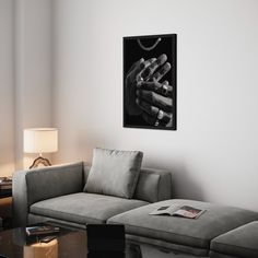 a living room with a couch, coffee table and painting on the wall in black and white