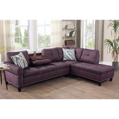 a living room with a purple couch and coffee table on the floor in front of a window