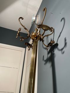 a tall golden pole with two lights on it's sides and a door in the background