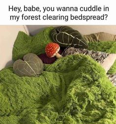 a bed covered in green fluffy blankets and pillows