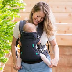 a woman holding a baby in a carrier