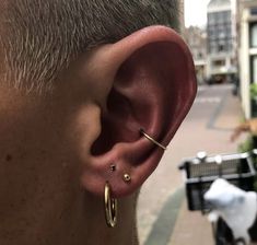 a close up of a person with ear piercings on their ears and in the street