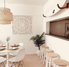 a dining room table with four chairs and a surfboard mounted to the wall above it