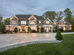 a large house with lots of windows and lights on it's front lawn area