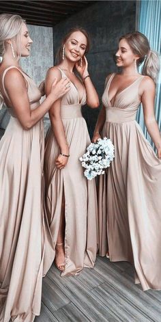 three beautiful women in long dresses standing next to each other