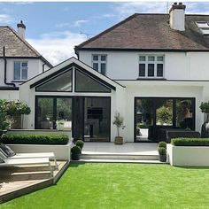 a large white house sitting on top of a lush green field