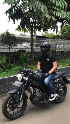 a man wearing a helmet sitting on a motorcycle