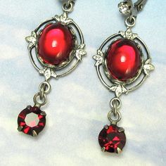 "Luminous red vintage Swarovski glass stones are set inside of little oval frames with red crystal drops hanging below. They red color glows with movement and lighting. They are set in antique silver filagree settings. They are rare Czech stones from the 1950s. The photos can not show their true beauty! They are almost 5/8\" wide and are 1 7/8\" from top to bottom They come on an earring card in a gift box ready for giving- even to yourself! Lightweight, elegant, vintage glass. Keep the past in Antique Silver Jeweled Earrings, Evening Red Metal Jewelry, Vintage Ruby Jewelry For Parties, Red Jeweled Jewelry For Evening, Red Evening Jewelry, Red Jeweled Earrings For Gift, Vintage Red Jewelry For Evening, Vintage Silver Earrings With Jewels, Antique Jeweled Red Jewelry