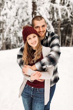 a man and woman hugging in the snow