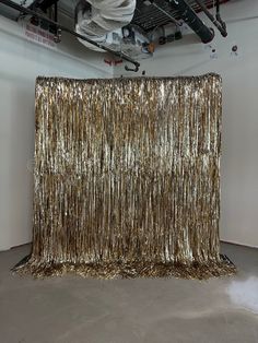 a large gold curtain is in the middle of a room with white walls and ceilings