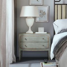 a bedroom scene with focus on the nightstand and bed side table in the foreground