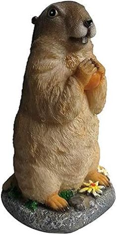 a figurine of a groundhog holding something in it's hands and looking up