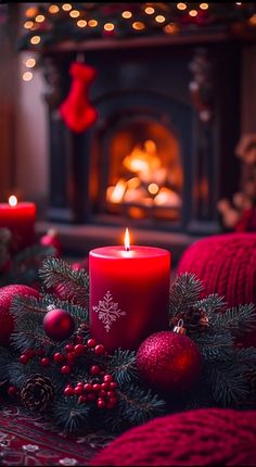 a lit candle sitting on top of a table next to christmas decorations and candles in front of a fireplace