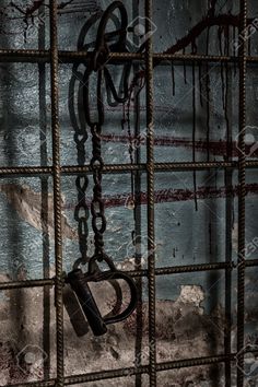 an old jail cell with chains hanging from it