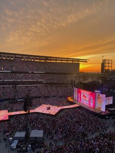 an aerial view of a concert venue at sunset with the sun setting in the background