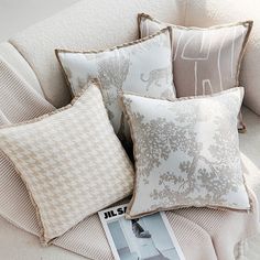 four pillows are sitting on a couch next to a magazine