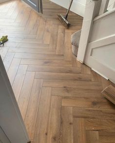 a hard wood floor with a mop on top of it next to a door