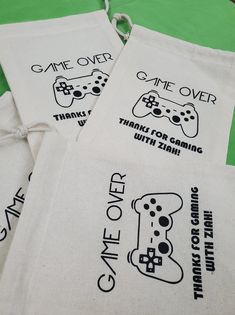 four bags with game over printed on them sitting on a green tablecloth covered floor