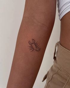 a woman's arm with a small tattoo on the left side of her arm