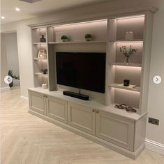 an entertainment center with built - in shelving and lighting