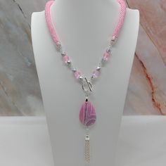 "Handmade and designed by me-one of a kind necklace-pink seed bead crocheted rope necklace-4 1/2\" long focal with a matte banded agate bead and a 2 1/2\" long chain tassel-pink mermaid glass beads and matte silver tone glass beads-silver tone toggle clasp in front-22\" long-silver tone findings" Handmade Pink Crystal Necklaces With Round Beads, Handmade Pink Crystal Bead Necklace, Pink Bohemian Lariat Jewelry, Bohemian Pink Lariat Jewelry, Pink Lariat Jewelry For Gifts, Pink Wire Wrapped Crystal Pendant Necklace, Handmade Pink Lariat Jewelry, Pink Multi-strand Jewelry With Faceted Beads, Pink Multi-strand Faceted Beads Jewelry