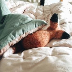 a stuffed animal laying on top of a bed