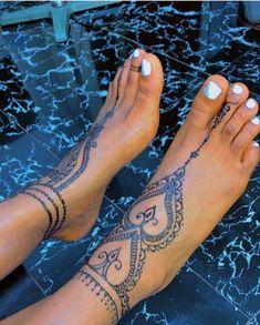 a woman's feet with tattoos on them