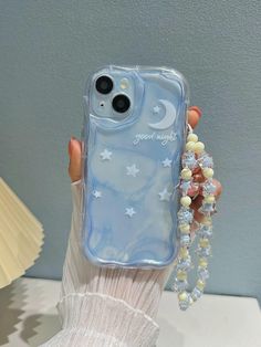 a woman's hand holding up a phone case with stars and moon on it