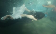 a woman floating in the water next to a table