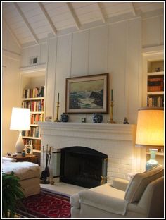 a living room filled with furniture and a fire place under a painting on the wall