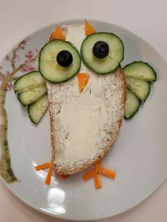 an owl sandwich with cucumbers and carrots on it