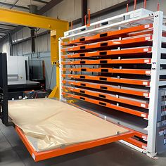 an orange and white shelf with several different types of items on it in a warehouse