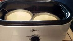 an oster toaster with three pans in it sitting on a counter top