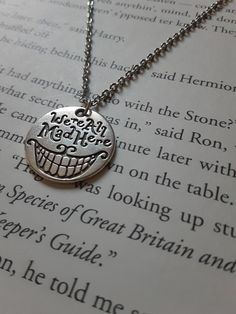 a close up of a book with a necklace on it's neck and an open book in the background