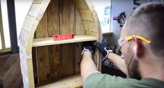 a man is working on a wooden shelf